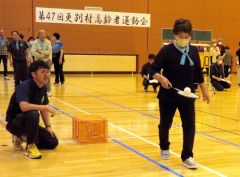ラケットでボールを運ぶリレーに取り組む参加者たち