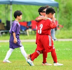 【第２トーナメント決勝・啓西―明和広陽】試合終了の笛が鳴り、うれしさのあまり感極まる仲間に手を添えるＭＦ（１０）小池燦雅主将（奥）