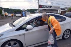ドライバーに啓発資料を手渡し交通安全を呼びかける参加者たち