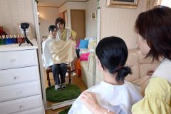 布を胸元に当てながら塚田さんににあう色を探してもらう（星野広翔撮影）