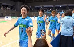 試合後、コートサイドのファンと笑顔でハイタッチを交わすエスポラーダ北海道の宮原勇哉（左）＝金野和彦撮影