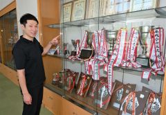 ショーケースに飾られている全国大会の優勝杯などを見て懐かしむ杉森輝大選手（金野和彦撮影）