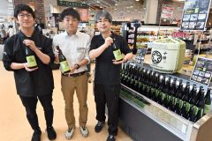 オリジナルラベルの記念酒を手にする関係者
