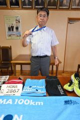 完走者に贈られたメダルを首に掛けて胸を張る重堂校長