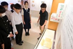 記念館の展示を活用し、ユリ根の特徴を生徒に解説する井上さん（右）