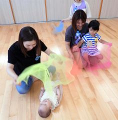 ふわふわのスカーフで遊ぶ親子