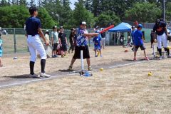 ティーバッティングで思い切りバットを振る子ども