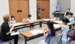 木村さん（左）に読書感想文の書き方を学ぶ子どもら