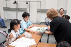 木村さん（右）に読書感想文の書き方を学ぶ子どもら