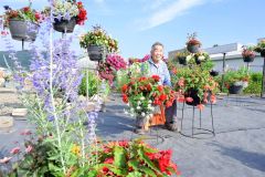花に囲まれ、笑顔を見せる木幡重雄さん