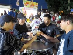 友人とビール片手にテーブルを囲んで盛り上がる来場者たち