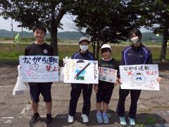 手書きのボードと小旗を手にする小中学生