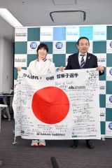 あいおいニッセイ同和損害保険の加川克仁地域担当常務出稿役員（右）から寄せ書きの「日の丸」を受け取り、笑顔を見せる小野選手（左）＝金野和彦撮影