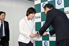 あいおいニッセイ同和損害保険の加川克仁地域担当常務出稿役員（右）から寄せ書きの「日の丸」を受け取る小野選手（左）＝金野和彦撮影