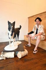 粉末の色素で色づけした蜜蝋で制作した犬が題材の作品と佐藤さん