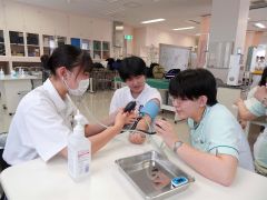 血圧測定を体験する高校生