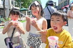 今季初の猛暑日となった帯広で、汗をかきながらかき氷を食べる子どもたち（２１日午後１時２５分ごろ、帯広まちなか歩行者天国で）