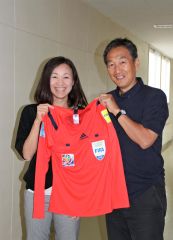 ２０１５年の女子Ｗ杯の審判のユニホームを手に笑顔を見せる手代木直美さん（左）と、帯南商高時の恩師の山崎裕彦さん