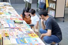 陳列された本を品定めする親子連れら