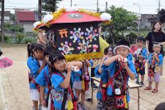 園庭でみこしを担ぐ園児