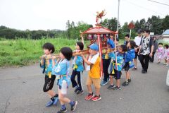 力を合わせて元気よくみこしを担ぐ子どもたち（長尾悦郎通信員撮影）