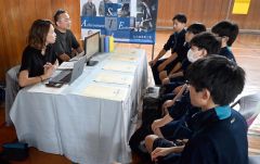 校内に開設された事業所ブースで会社説明などを聞く生徒ら