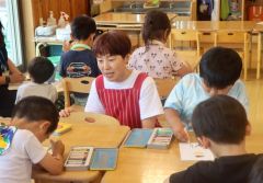 認定こども園ほろんで子どもたちのサポートをする藤原さん（中央）
