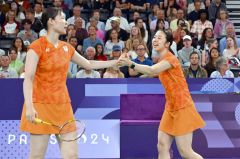 【女子ダブルス予選ラウンドＡグループ・マレーシア戦】第１ゲーム、相手からポイントを奪い１１－１２と追い上げ、松本麻佑（左）とタッチを交わす永原和可那（右）＝金野和彦撮影