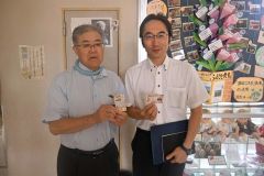 渋沢栄一をモチーフにした名刺を交換する山下教育長(左)と嘉藤校長