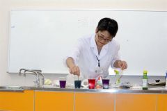 茹で汁に重曹などを加えて色の変化を実演する浦木さん