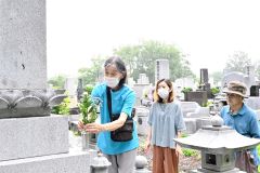 ご先祖へ花を供える参拝者(13日午前9時45分ごろ、帯広市内の緑ケ丘墓地で)