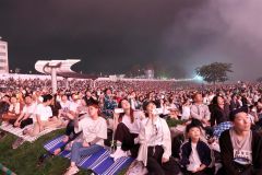 会場の河川敷から堤防までを埋めた観客。そろって夜空を見上げ大輪に酔いしれた（助川かおる通信員撮影）