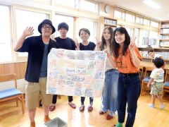 ２０年後の自分に宛てた寄せ書きを手にする参加者