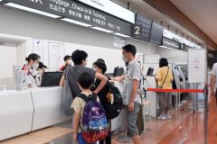 カウンターで手続きをする帰省客