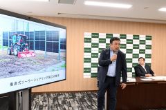 垂直型の太陽光パネルについて説明する瀧口社長（中央）と長澤学長