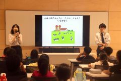 子どもたちに地球温暖化について説明する八木さん（左）と佐々木さん