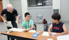 英語のカードゲームを楽しむ児童ら。左は講師のピナールさん