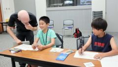 英語のカードゲームを楽しむ児童ら。左は講師のピナールさん