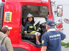 制服を着て消防車に乗り込む子ども