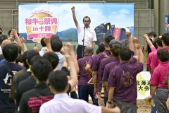 右手を高々と掲げ「ガンバロー」と三唱する道和牛振興協議会の佐藤副会長（須貝拓也撮影）