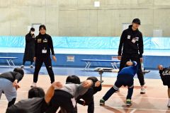 子どもたちに滑走時のフォームについて指導する野々村太陽選手(右)と山根佳子選手(左)=金野和彦撮影