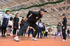 野々村太陽選手(左手前)から滑走のフォームを学ぶ子どもたち。右は山根佳子選手(金野和彦撮影)