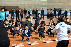 ウォーミングアップをして体をほぐす子どもたち(金野和彦撮影)