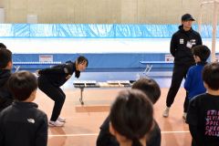 子どもたちに滑走時のフォームについてアドバイスをする山根佳子選手(左)と野々村太陽選手(金野和彦撮影)