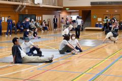 受け付けを済ませてアルミマットの上で過ごす訓練参加者（１日午前９時４０分ごろ）