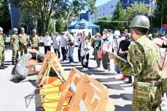 災害時の自衛隊の活動について説明を受ける訓練参加者（１日正午ごろ）