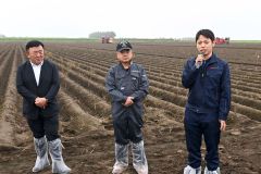 じゃがいも畑の前であいさつをする(左から)田崎一也社長、橋詰仁組合長、杉浦大斗幕別支所長(5日、午前10時ごろ、帯広市以平町で。金野和彦撮影)