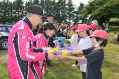 児童から手作りのリースを受け取る選手たち(金野和彦撮影)