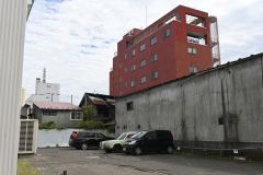 鎮火後の現場。共同住宅の左の建物が火災現場。(帯広市西1南7、13日午前11時10分ごろ)