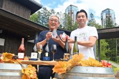 占冠村のシカ肉と北海道のワインを楽しめる「焚火ワインアペロ」をPRする(左から)田中村長、渡辺総支配人。手荷物のは占冠村のクラフトジン・リキュール